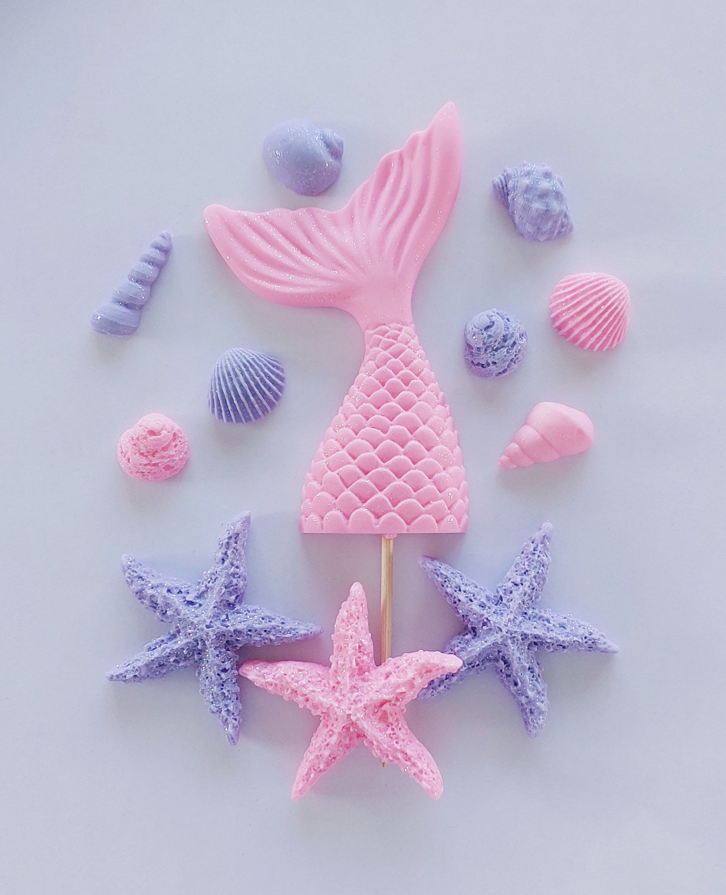 Pink sparkling mermaid tail cake topper surrounded by starfish and shells, edible fondant decorations by Cake Candy NZ