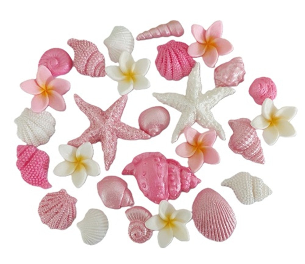A selection of shells and tropical flowers in pinks and white. Edible fondant icing decorations by Cake Candy NZ.