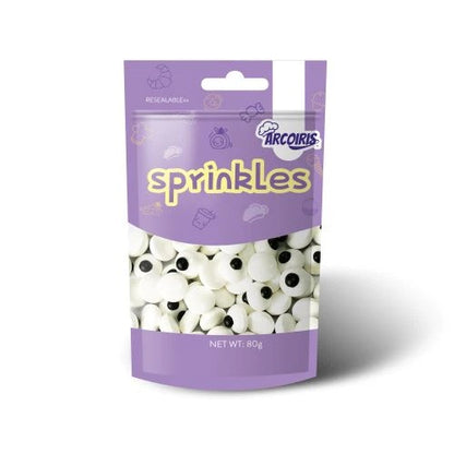 A bag of Arcouris Sprinkles candy, featuring a purple resealable stand-up pouch with a clear window showing white sprinkles with black eyes inside.