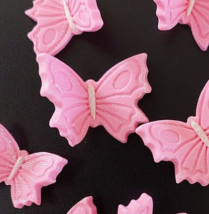 Pink butterfly-shaped candies on a black background