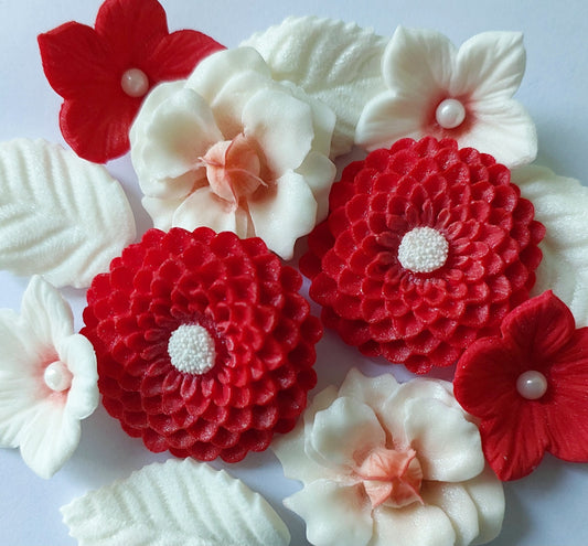 A collection of edible fondant icing flowers and leaves, primarily in red and white colors, some decorated with sugar pearls by Cake Candy NZ