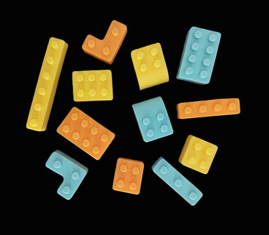 Colorful  building blocks scattered on a black background, edible chocolate cake decortions