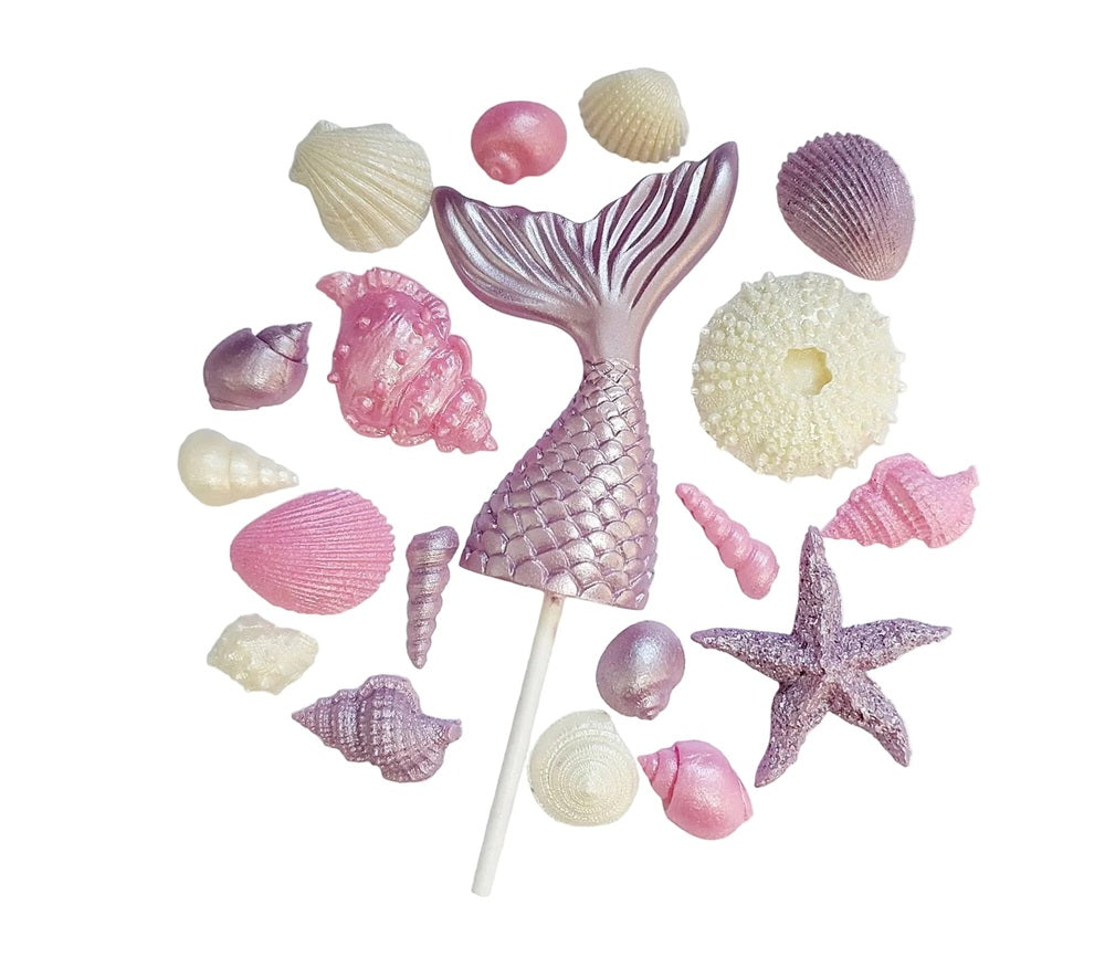 A mermaid tail with assorted shells in lilac, pink and cream colours. Edible chocolate decorations by Cake Candy NZ.