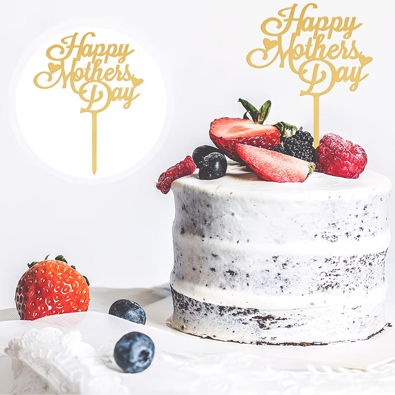 White cake with berries and 'Happy Mother's Day' toppers on a white background