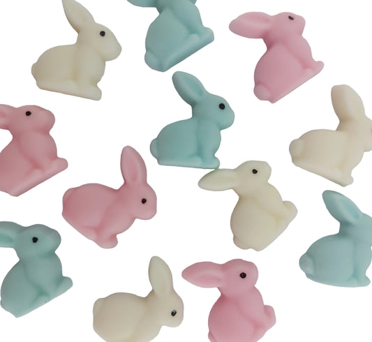 Pastel-colored bunny figurines, edible chocolate cake decorations