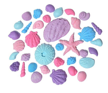 Assorted edible fondant shells in blues, purples, and pinks, with a shimmer finish. Made by Cake Candy NZ
