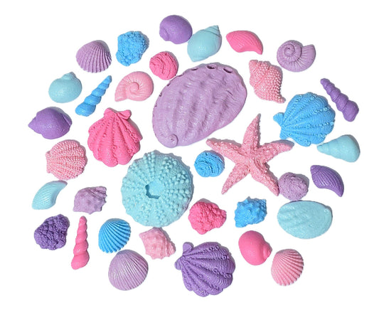 Assorted edible fondant shells in blues, purples, and pinks, with a shimmer finish. Made by Cake Candy NZ