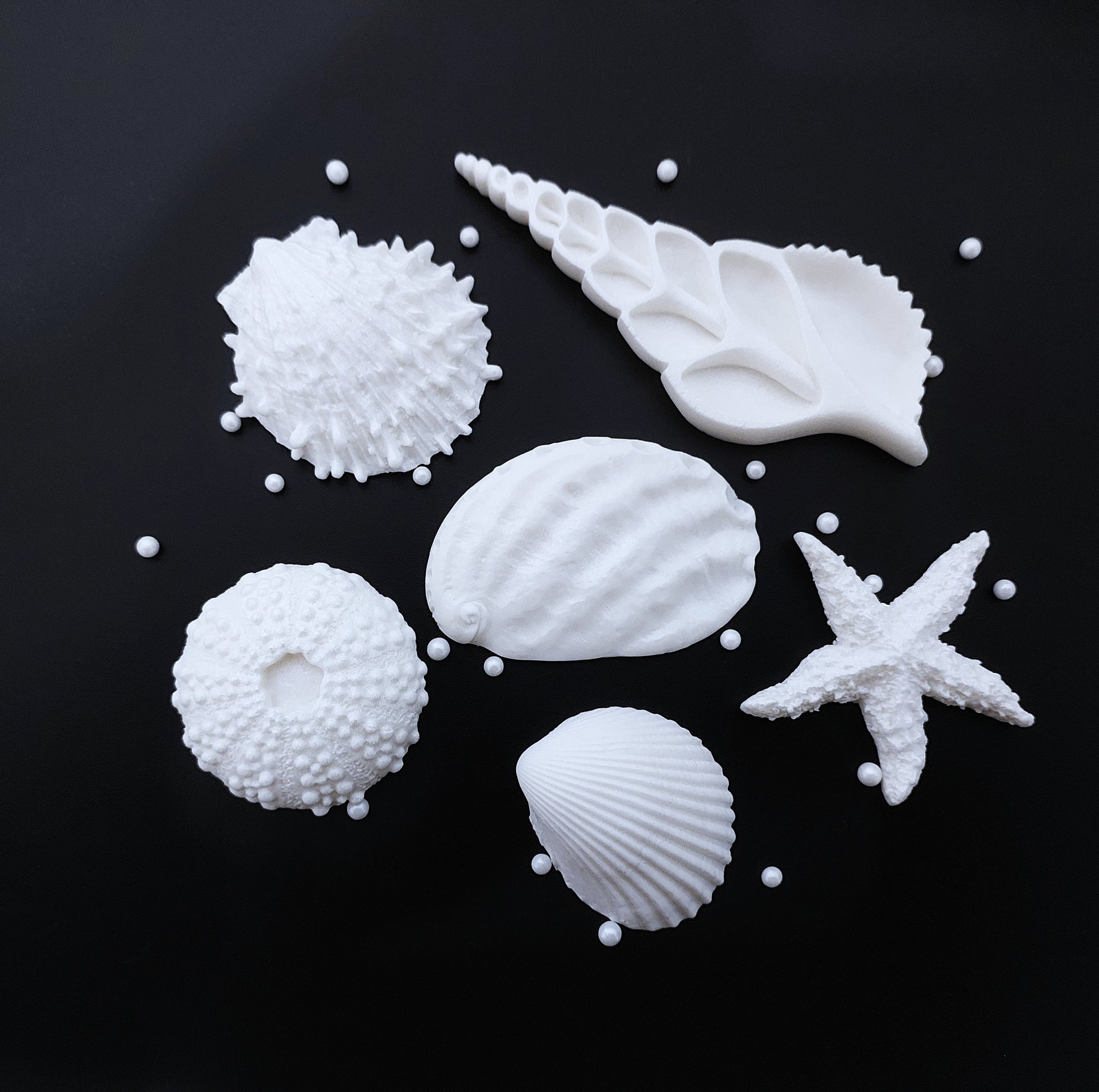 A set of 6 large white fondant icing shells with sugar pearls