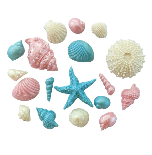 Colorful seashells and a starfish in pale pink, blue and cream colours. Edible chocolate decorations by Cake Candy NZ
