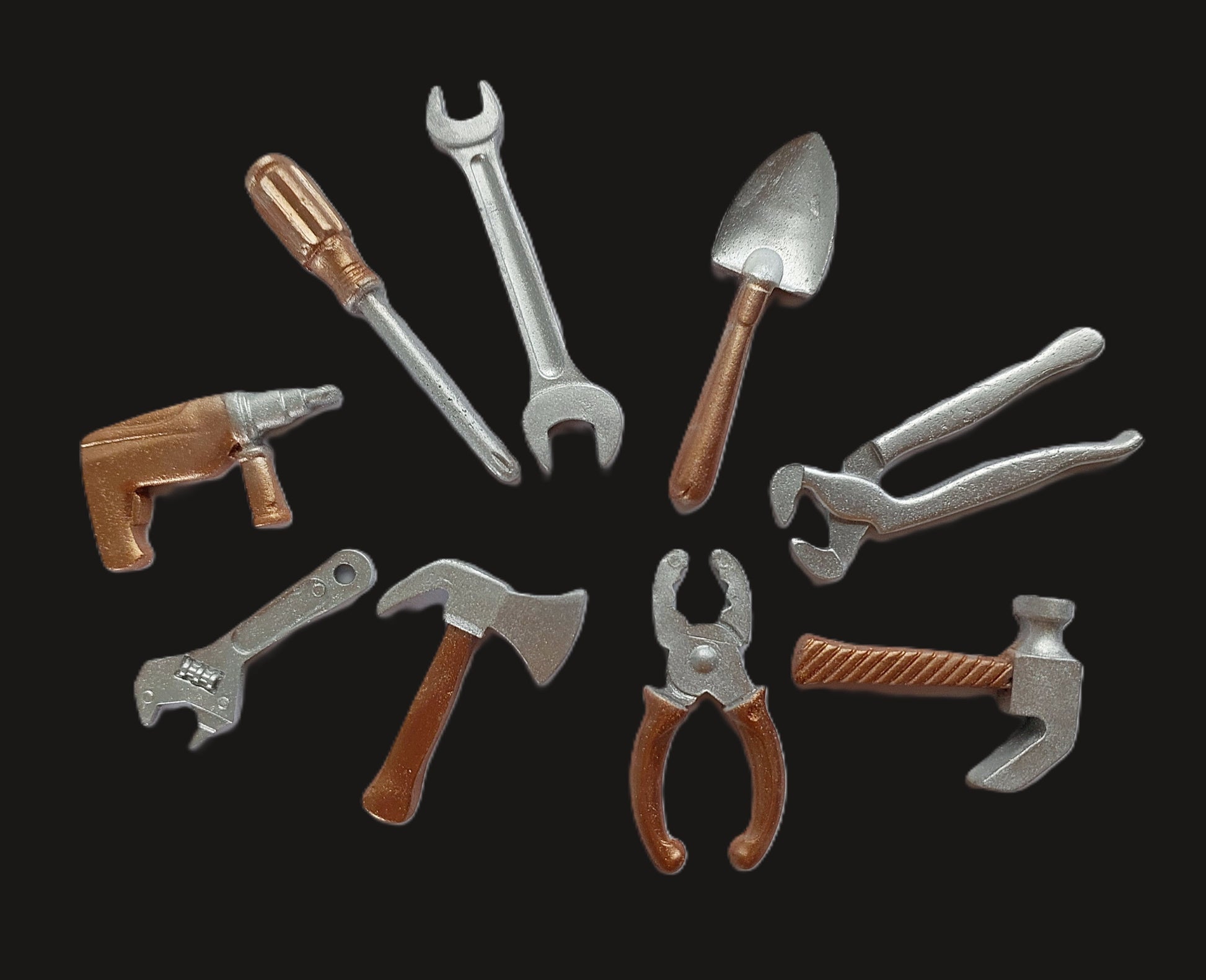 A collection of various edible fondant cake decorations by Cake Candy NZ. Designed to look like tools such as a wrench, hammer, and pliers, with a shimmer finish.